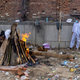 Relatives stand next to the burning funeral pyre of a person, who died due to the coronavirus disease (COVID-19), at a crematorium ground in New Delhi